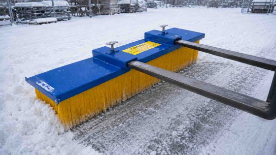 forklift sweeper pushing snow