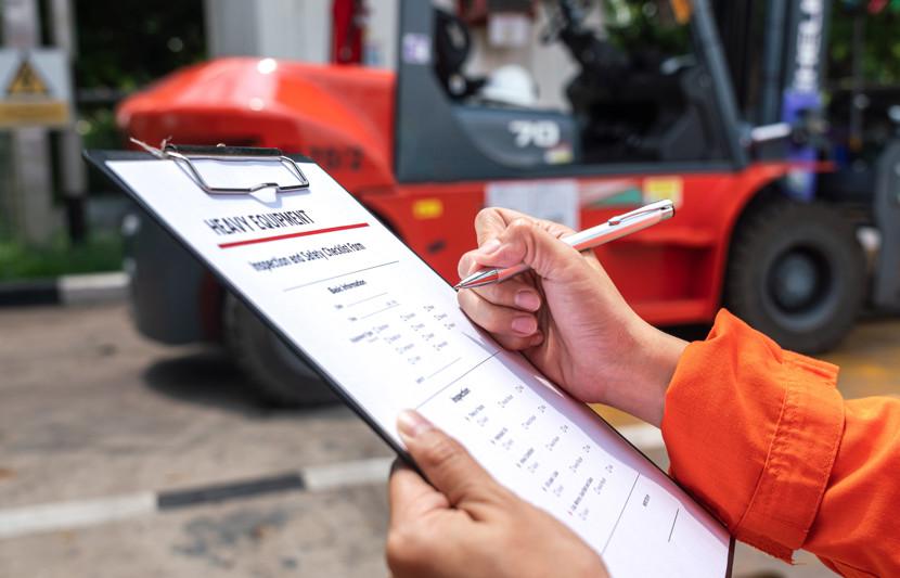 Competent person carrying out a LOLER Thorough Examination of a forklift attachment